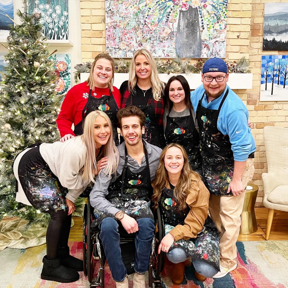 A group of Treadstone employees smiling at the camera during a paint & sip class.