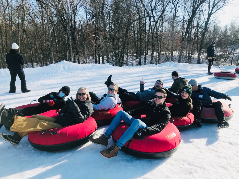The photo shows a group of Treadstone employees in snow tubes at Cannonsburg.