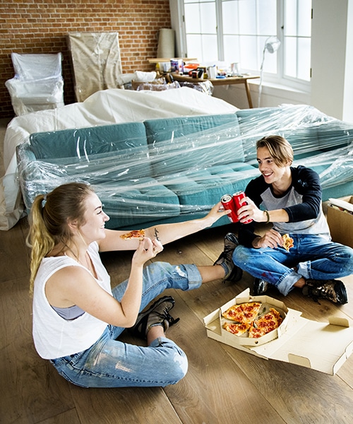 young couple celebrating home purchase with mortgage while moving in to neighborhood